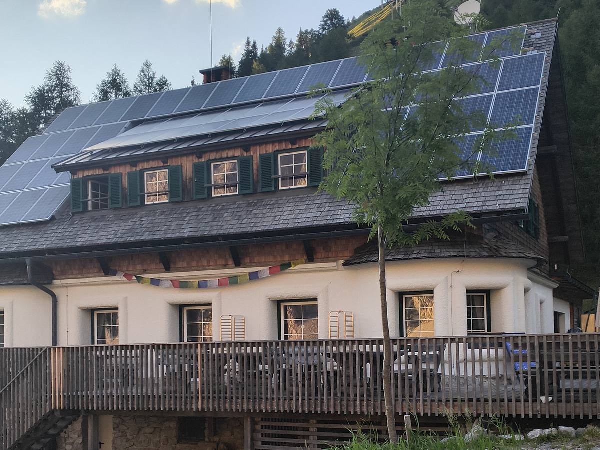 Die Klagenfurter Hütte am Abend: Fassade mit Holzterrasse und Solaranlage auf dem Dach